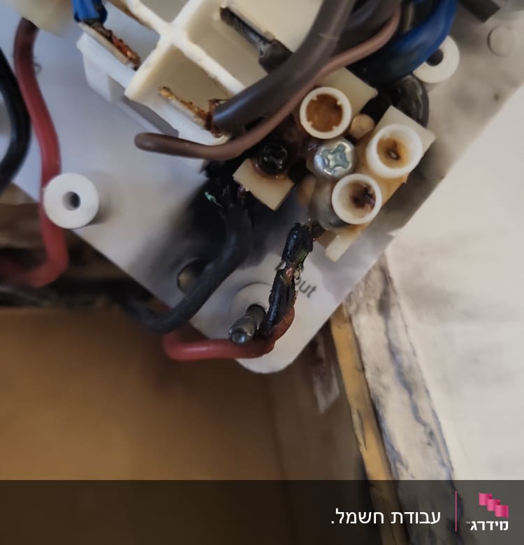חוטי חשמל שרופים ומחוברים למפסק חשמלי
